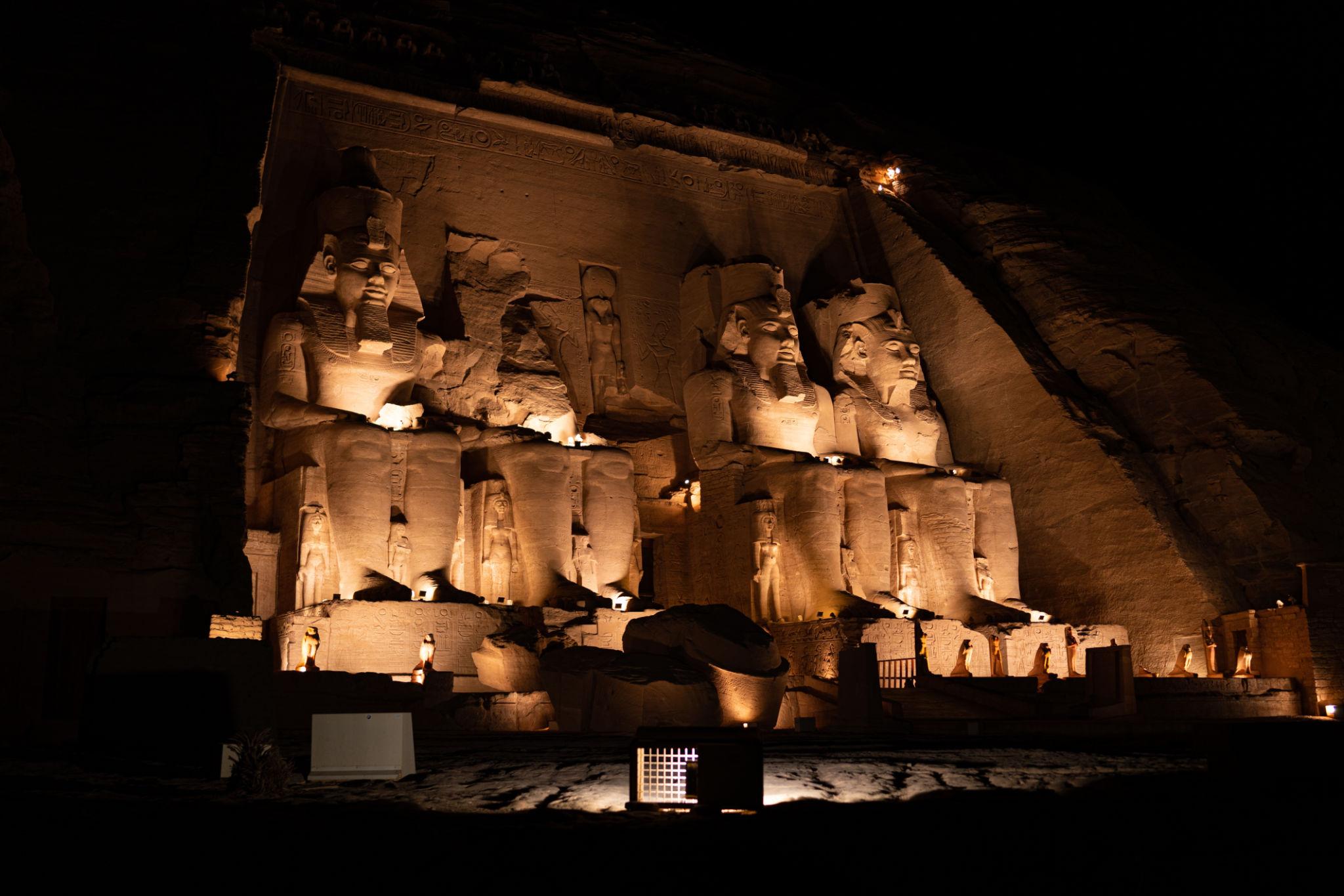 Four colossal statues of Ramesses II at Abu Simbel temple dramatically lit at night