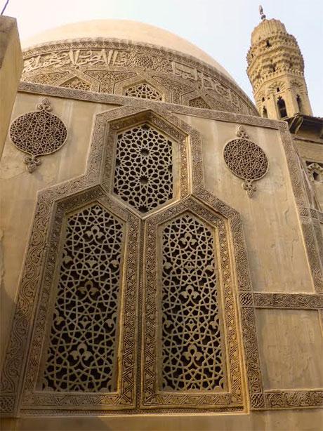 Carved stucco facade with geometric lattice screens and dome on a City of the Dead mausoleum