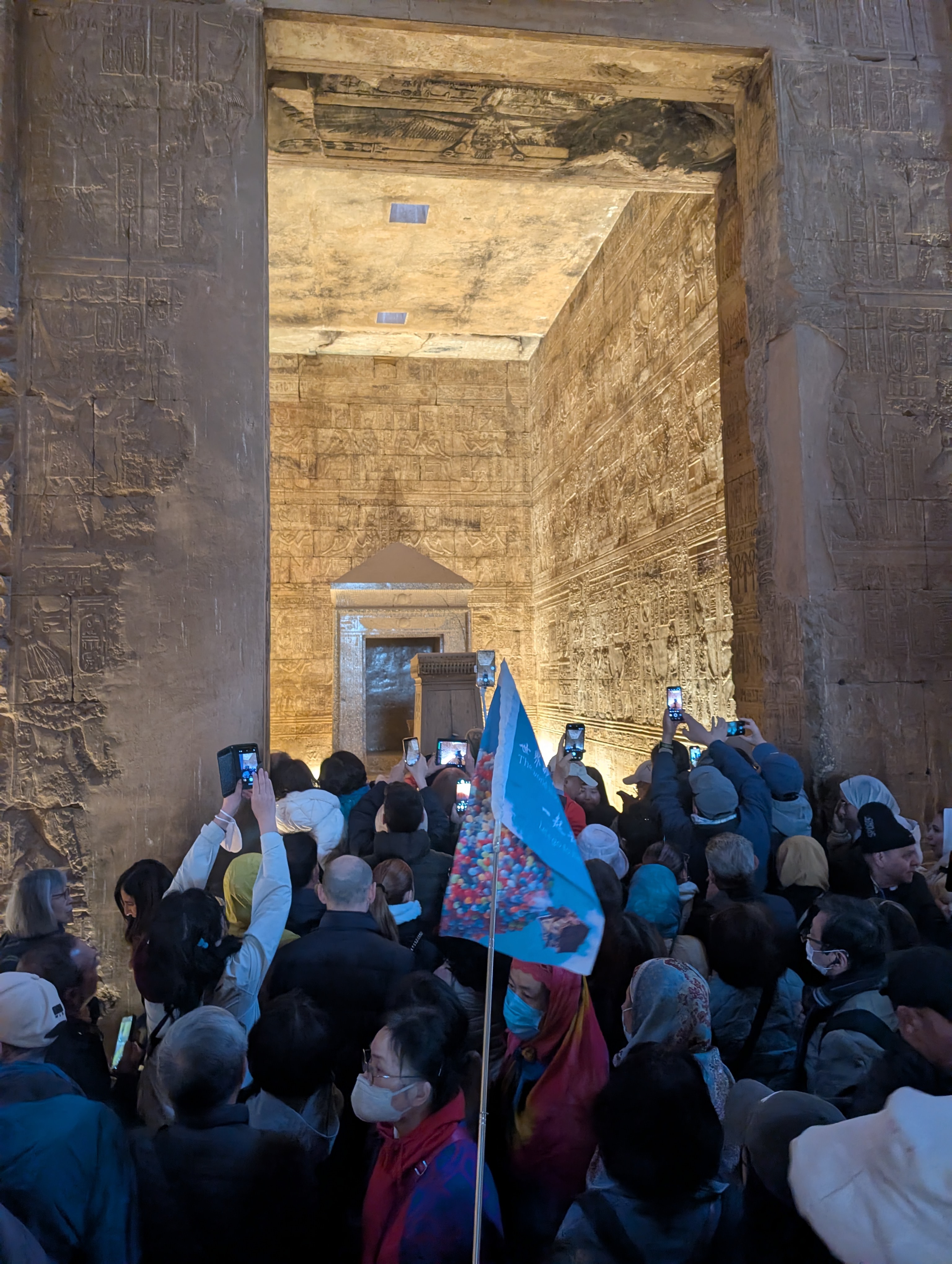 Crowd of visitors photographing the inner hall of the Temple of Edfu.