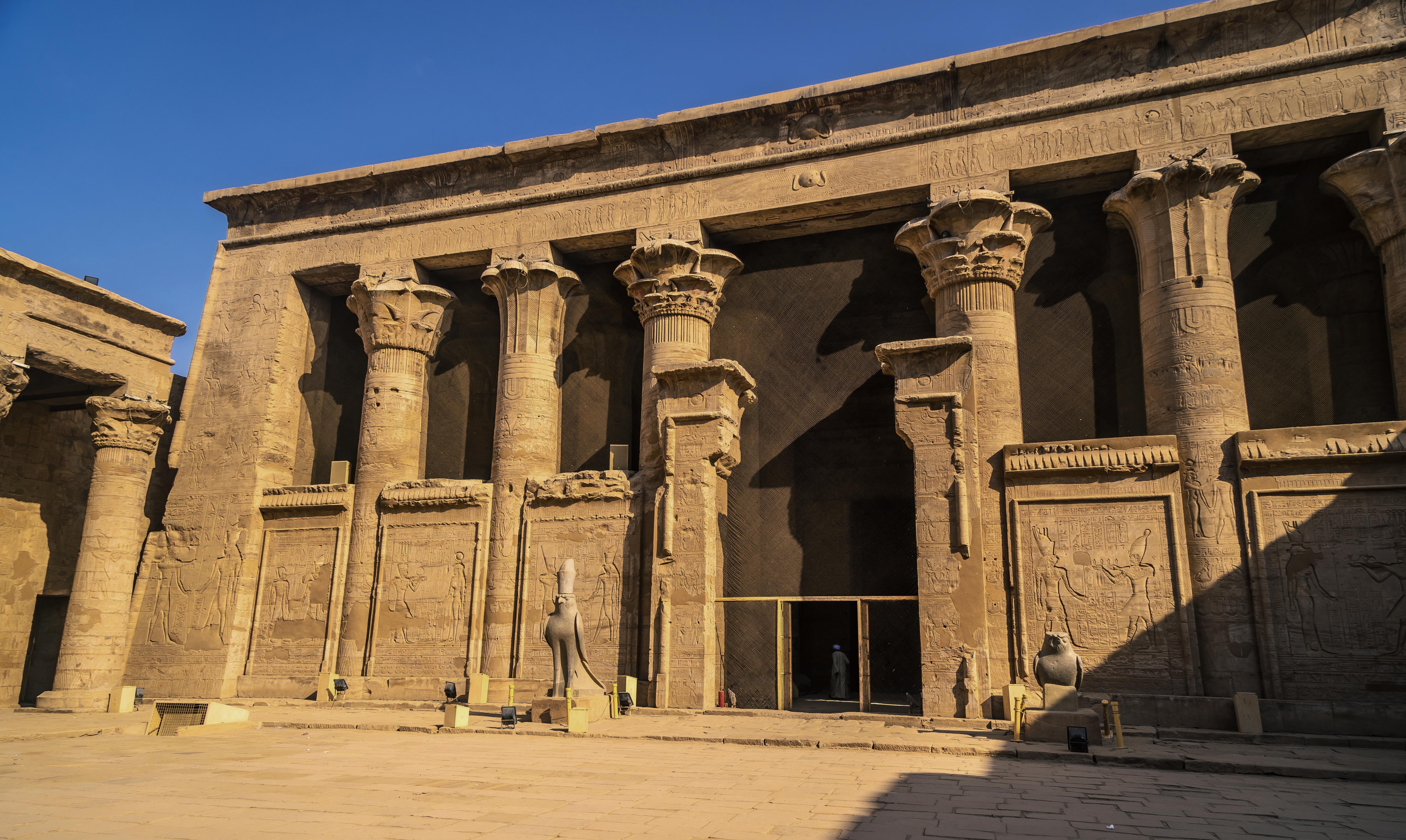 Overview of the colonnaded forecourt of the Temple of Edfu in afternoon light.