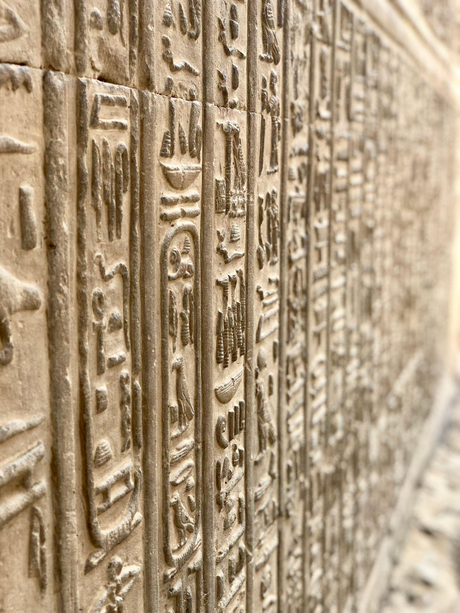 Closeup of finely carved hieroglyphic columns on a wall of the Temple of Edfu.