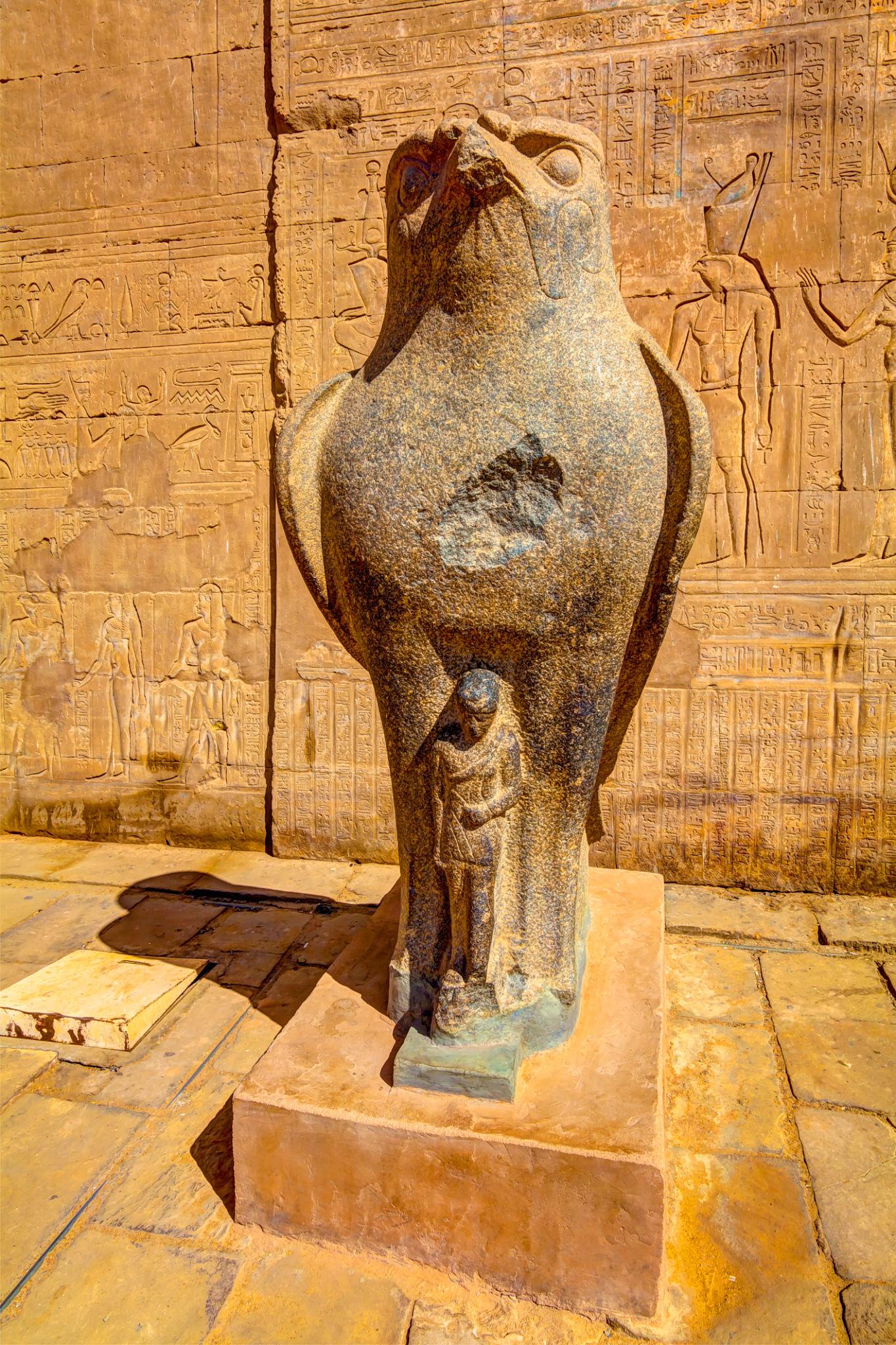 Tall granite Horus falcon statue on a pedestal at the Temple of Edfu.