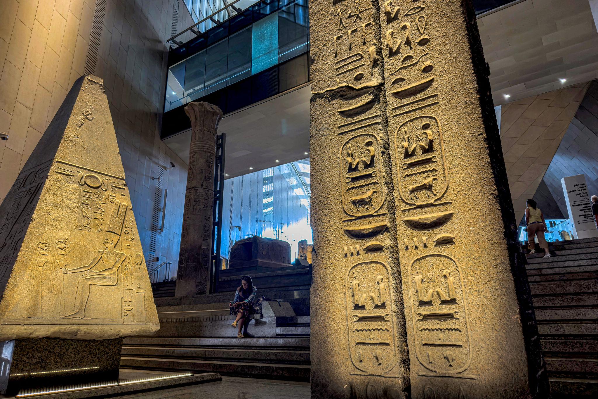 Ancient Egyptian obelisk and stele with carved hieroglyphics inside the NMEC atrium