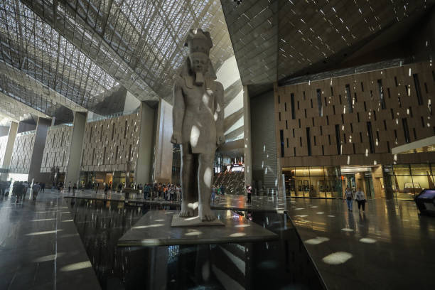 Towering ancient Egyptian pharaoh statue stands in the grand sunlit atrium of the NMEC