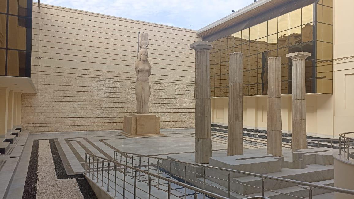 Museum courtyard featuring a caryatid statue and reconstructed Doric columns