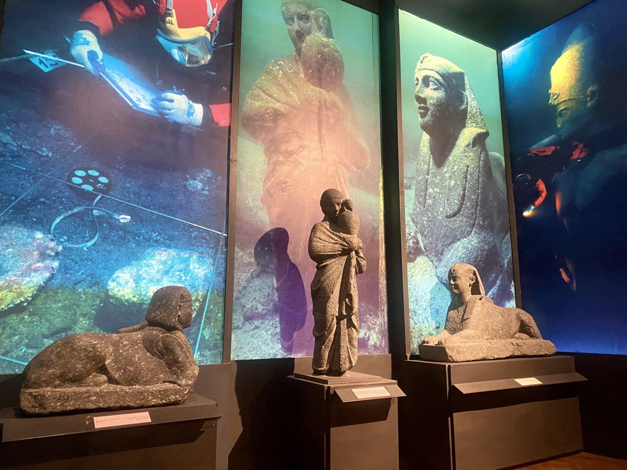 Sphinxes and statues recovered from Alexandria's sunken harbor beside underwater excavation photos