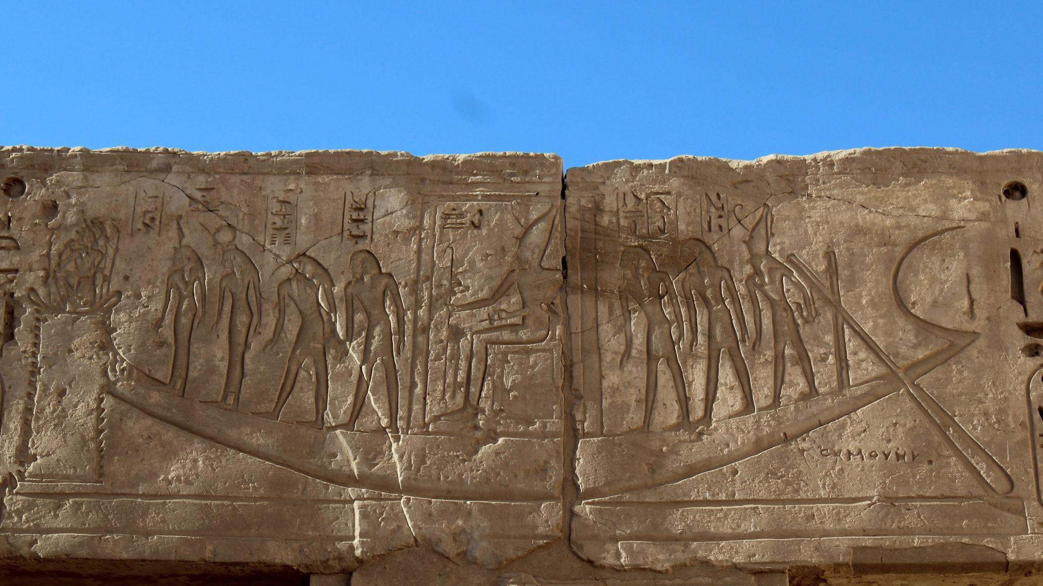 Weathered relief showing priests carrying a sacred barque at Medinet Habu.