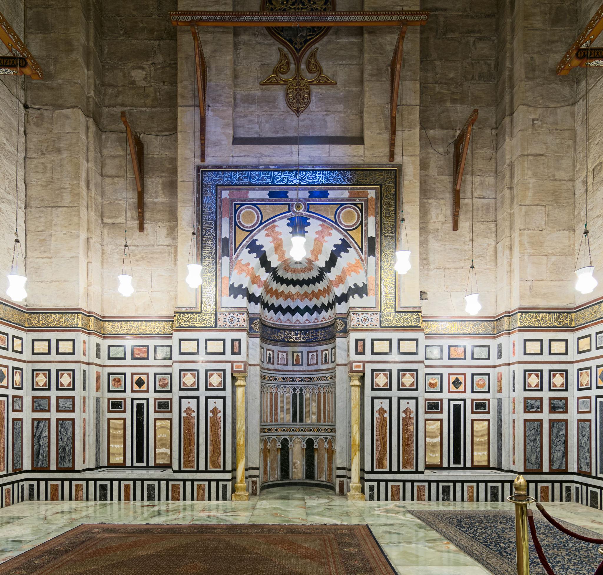 Polychrome marble mihrab niche flanked by geometric inlaid wall panels in the mausoleum