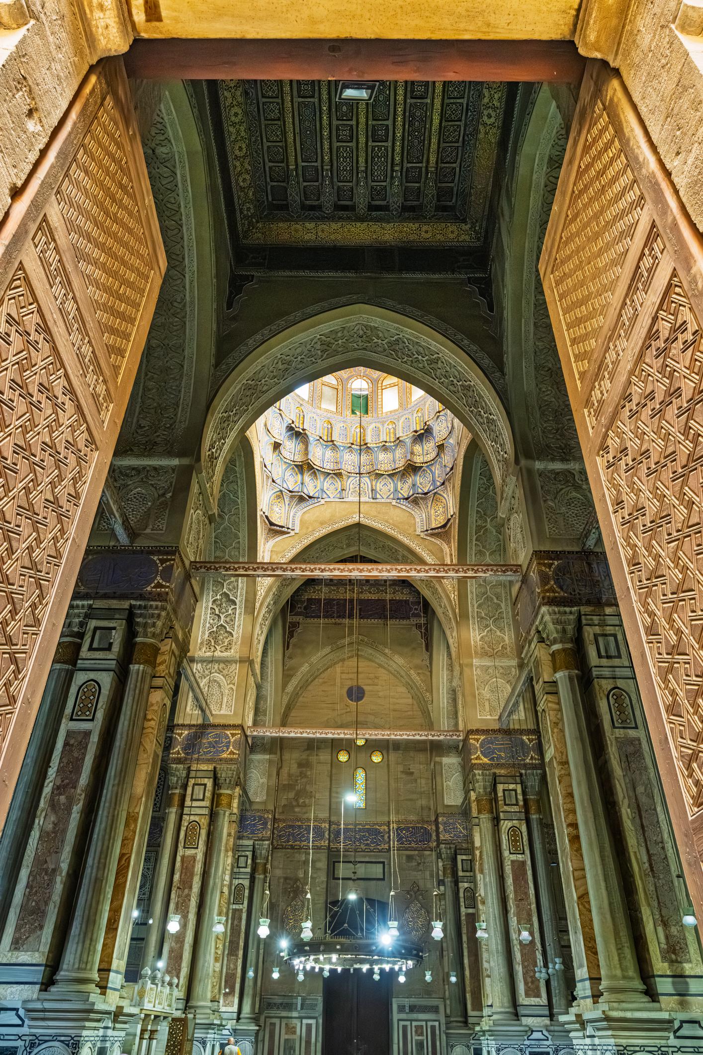 Towering stone portal with carved muqarnas vaulting at the Sultan Hassan entrance