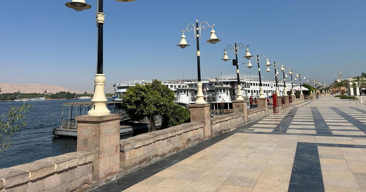 Nile cruise ships moored at the Luxor corniche quay under clear blue sky