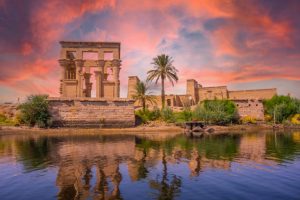 Incredible orange sunrise at the temple of Philae, a Greco-Roman construction seen from the Nile river, a temple dedicated to Isis, goddess of love. Aswan. Egyptian