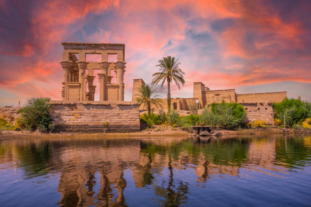 Incredible orange sunrise at the temple of Philae, a Greco-Roman construction seen from the Nile river, a temple dedicated to Isis, goddess of love. Aswan. Egyptian